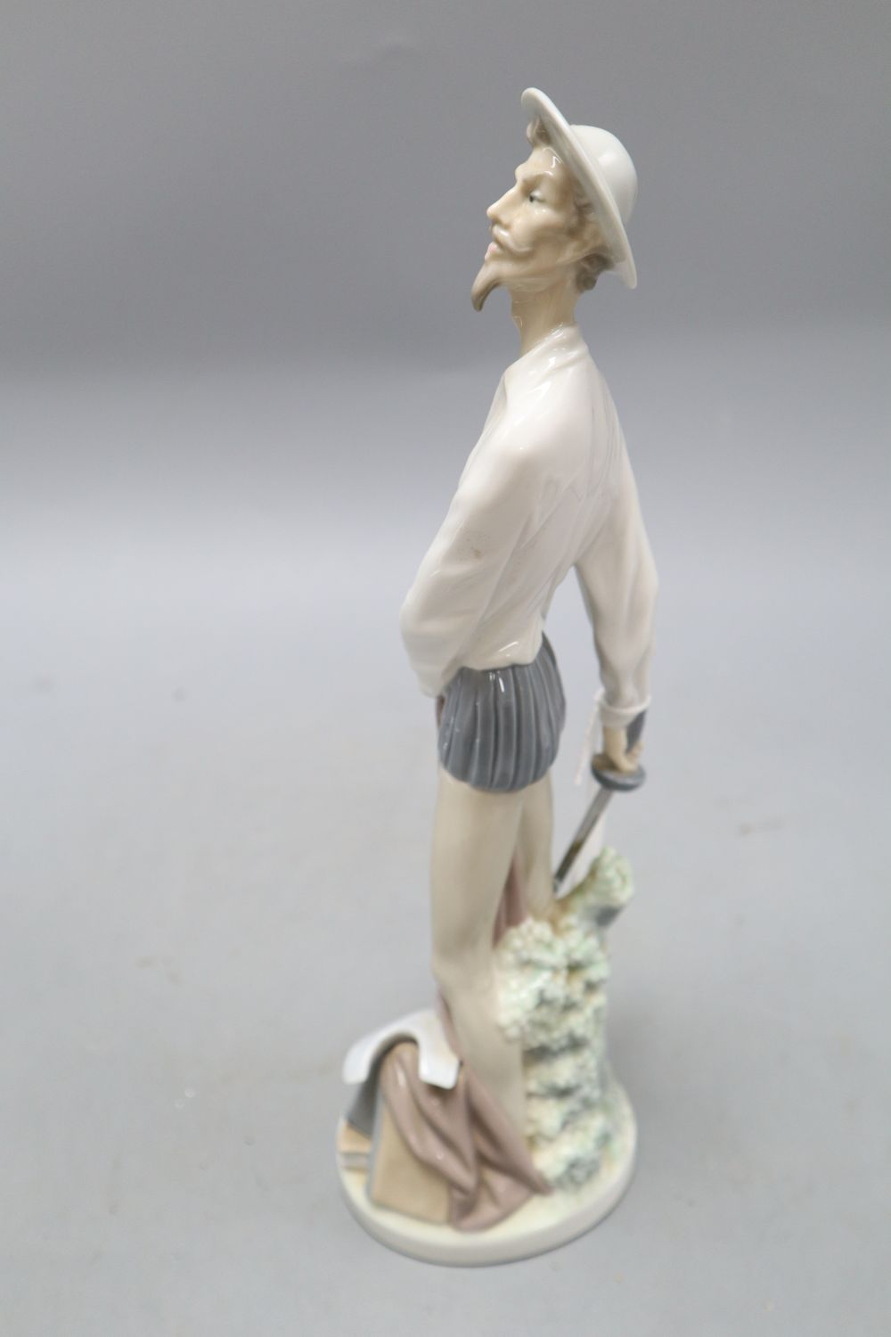 A Lladro figure of Don Quixote standing with his sword, no.5854 and a Nao figure of a Spanish dancer, tallest 34cm